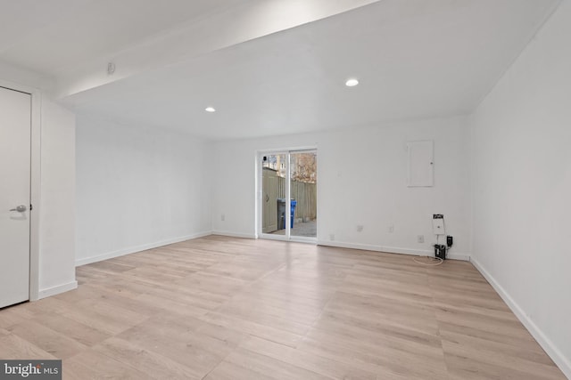 unfurnished room featuring electric panel and light hardwood / wood-style flooring