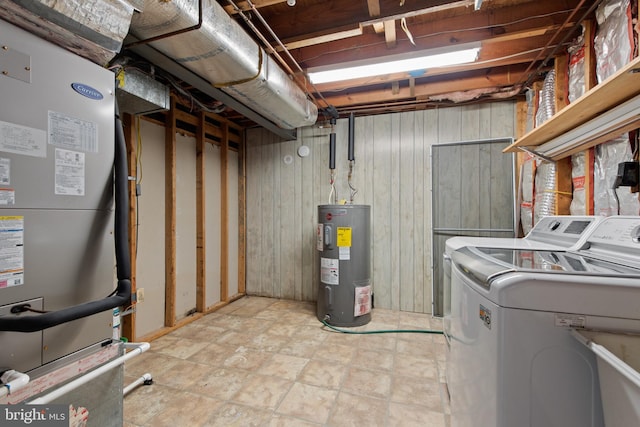 laundry area featuring washer and clothes dryer, heating unit, wood walls, and water heater