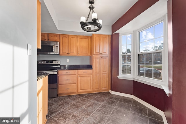 kitchen with a wealth of natural light, pendant lighting, a notable chandelier, and appliances with stainless steel finishes