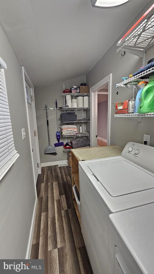 clothes washing area featuring dark hardwood / wood-style flooring and washer and dryer