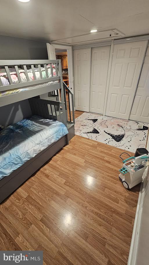 bedroom with wood-type flooring and a closet