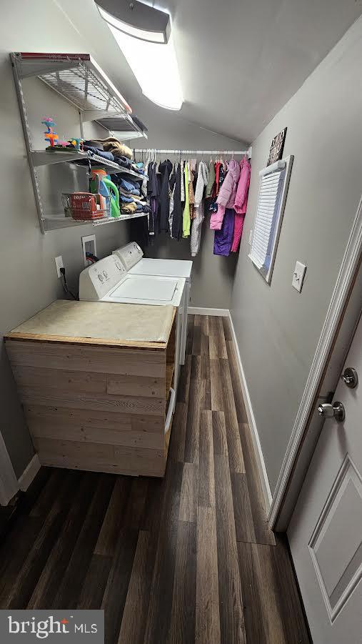 clothes washing area with washer and clothes dryer and dark hardwood / wood-style floors