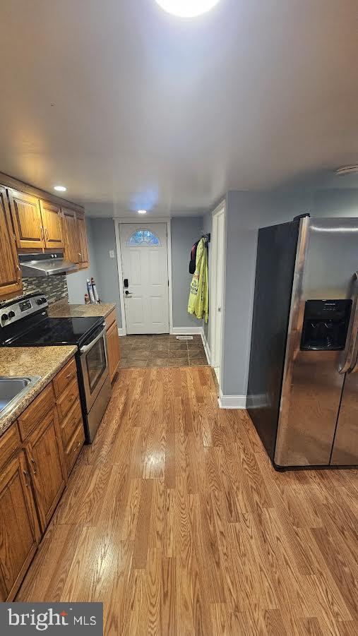 kitchen featuring stainless steel appliances, tasteful backsplash, and light hardwood / wood-style floors