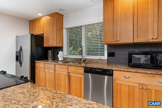 kitchen featuring sink, light stone countertops, stainless steel appliances, and tasteful backsplash