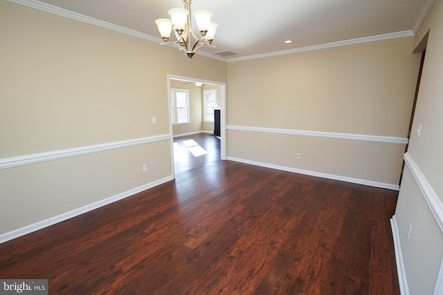 empty room featuring crown molding, dark wood-type flooring, and an inviting chandelier