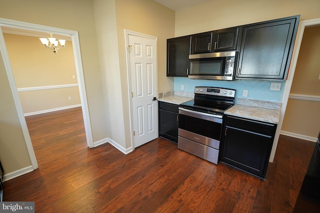 kitchen featuring an inviting chandelier, dark hardwood / wood-style flooring, pendant lighting, decorative backsplash, and appliances with stainless steel finishes