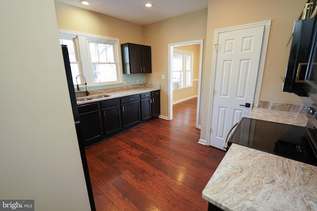 kitchen featuring light stone counters, sink, dark hardwood / wood-style floors, and range