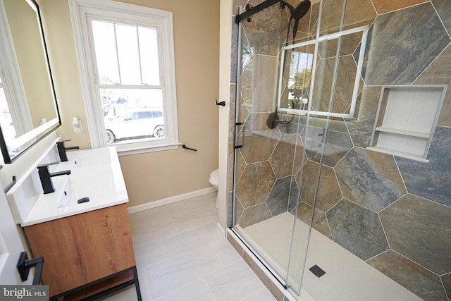 bathroom featuring tile patterned flooring, vanity, a shower with shower door, and toilet