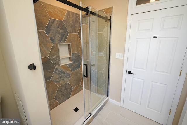 bathroom featuring tile patterned floors and a shower with shower door