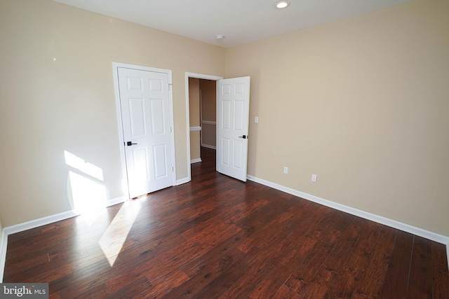 unfurnished bedroom with dark hardwood / wood-style floors