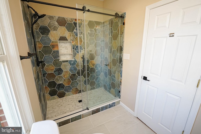 bathroom with tile patterned floors and a shower with door