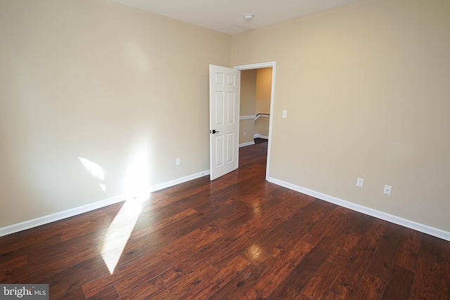 empty room with dark hardwood / wood-style flooring