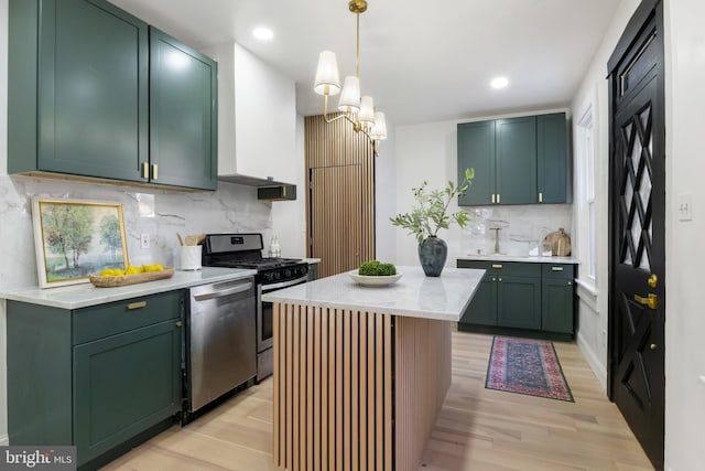 kitchen featuring appliances with stainless steel finishes, tasteful backsplash, light hardwood / wood-style flooring, and hanging light fixtures