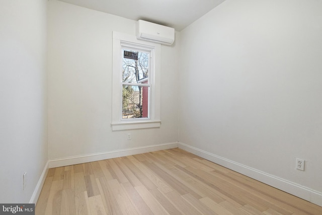 unfurnished room with light hardwood / wood-style flooring and a wall mounted AC