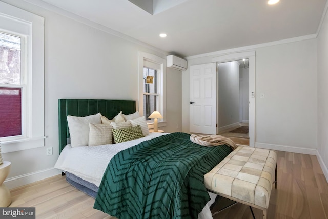 bedroom featuring crown molding, a wall mounted air conditioner, and light wood-type flooring