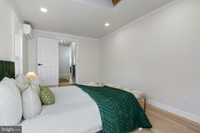 bedroom with hardwood / wood-style floors, a wall unit AC, crown molding, and a notable chandelier