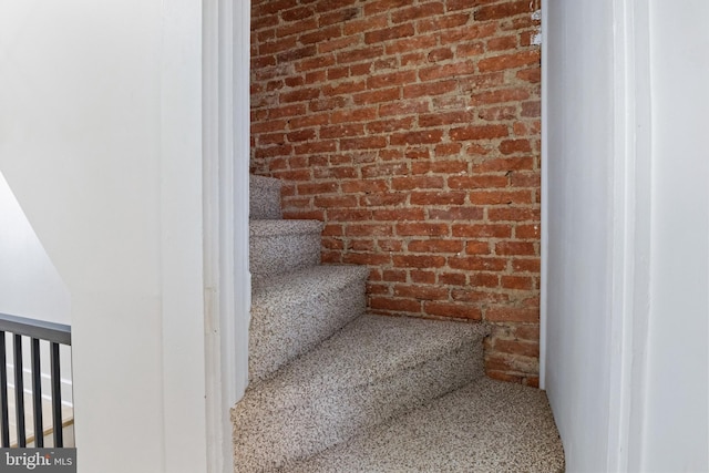 stairs featuring brick wall