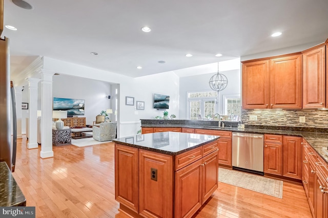 kitchen with pendant lighting, an inviting chandelier, sink, stainless steel dishwasher, and a kitchen island