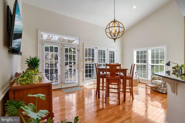 dining space featuring a healthy amount of sunlight, light wood-type flooring, and a chandelier