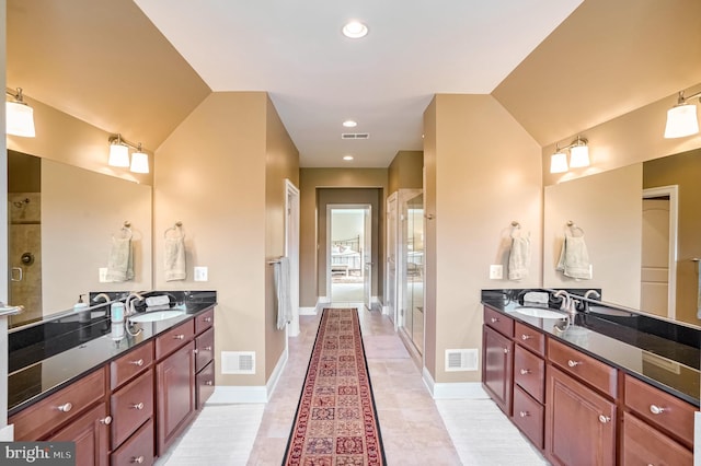 bathroom featuring vanity, tile patterned floors, and vaulted ceiling