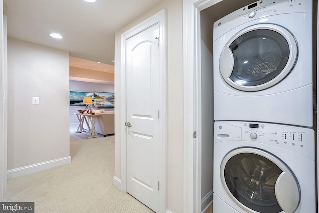 clothes washing area with light carpet and stacked washer and dryer