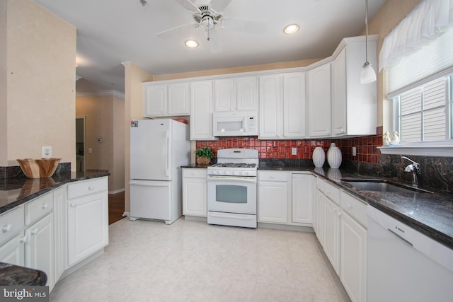 kitchen with pendant lighting, sink, white cabinets, dark stone counters, and white appliances