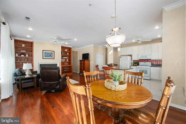 dining space featuring ceiling fan, hardwood / wood-style floors, and crown molding