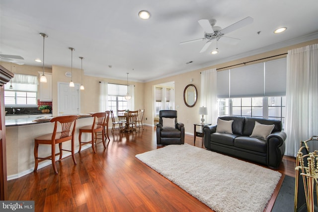 living room featuring crown molding, ceiling fan, and dark hardwood / wood-style flooring