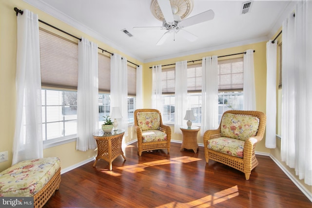 sitting room with ceiling fan, crown molding, plenty of natural light, and dark wood-type flooring