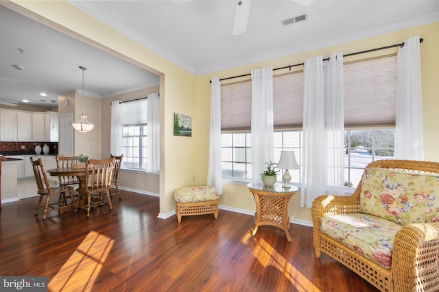 sitting room featuring ceiling fan, crown molding, and dark wood-type flooring