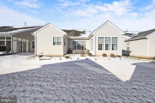 snow covered back of property with a carport