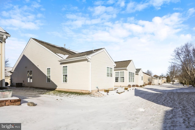 snow covered house featuring central AC