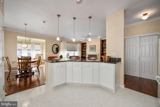 kitchen with white cabinetry, pendant lighting, built in features, and ornamental molding