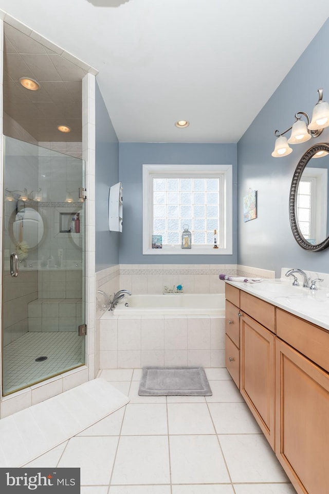 bathroom with tile patterned floors, vanity, and shower with separate bathtub