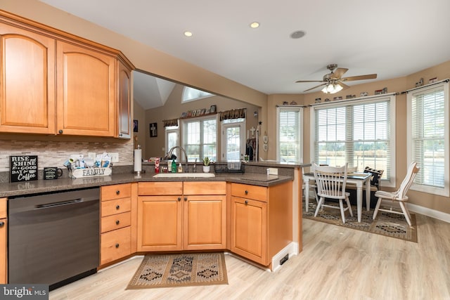 kitchen with kitchen peninsula, black dishwasher, a healthy amount of sunlight, and sink