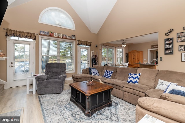 living room featuring hardwood / wood-style flooring, high vaulted ceiling, and ceiling fan