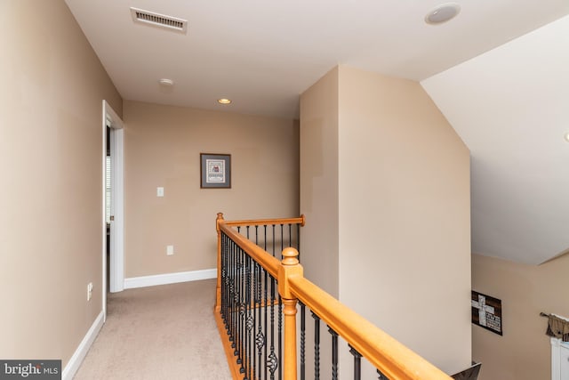 hallway with carpet flooring and vaulted ceiling