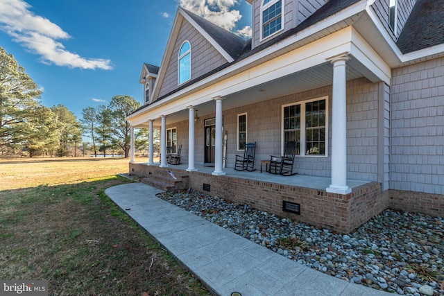 doorway to property featuring a porch and a yard