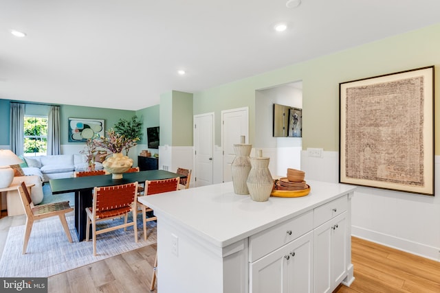 kitchen featuring white cabinets, a kitchen island, and light hardwood / wood-style floors