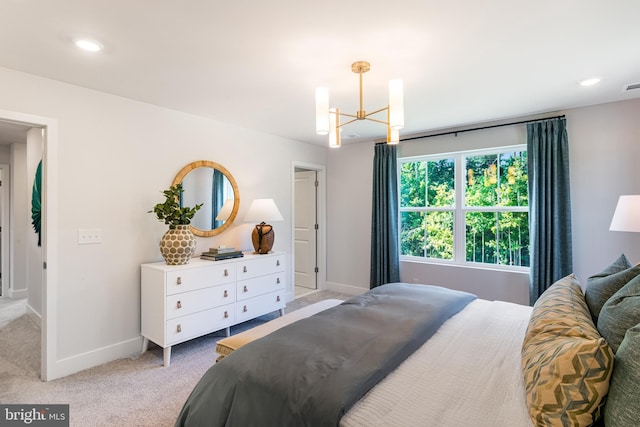 bedroom with light carpet and an inviting chandelier