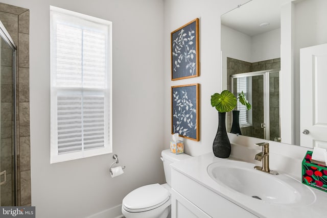 bathroom featuring vanity, toilet, and a shower with shower door