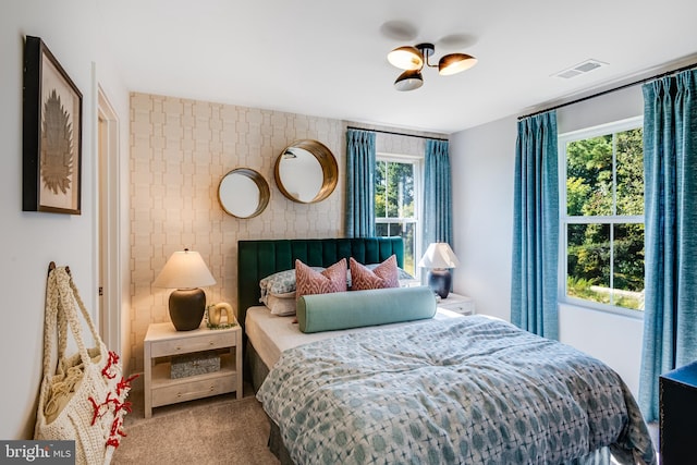 bedroom with carpet floors and multiple windows