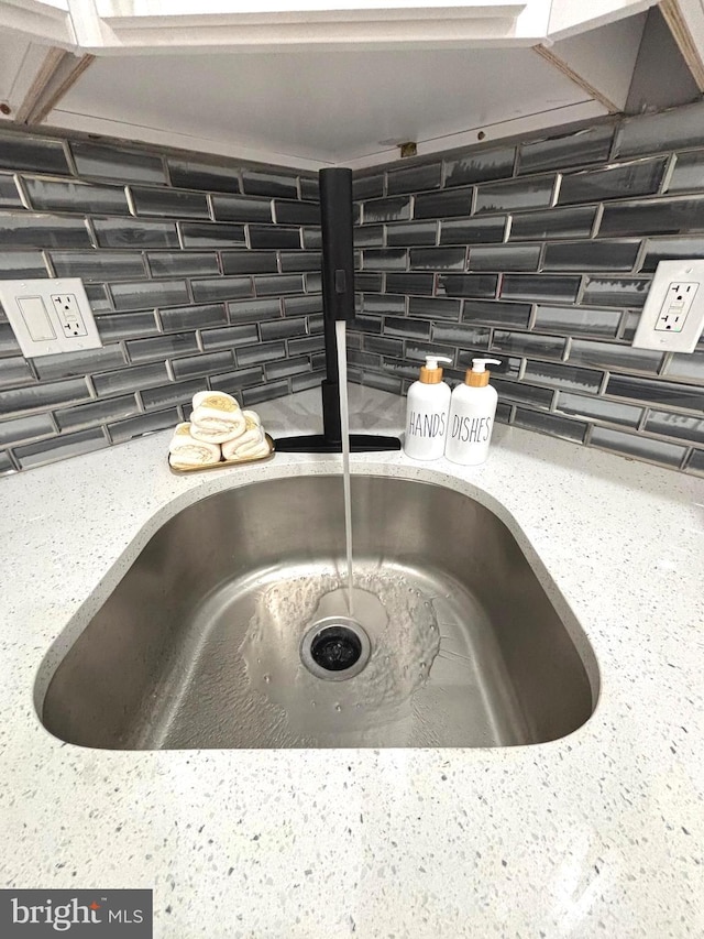 interior details featuring tasteful backsplash and sink