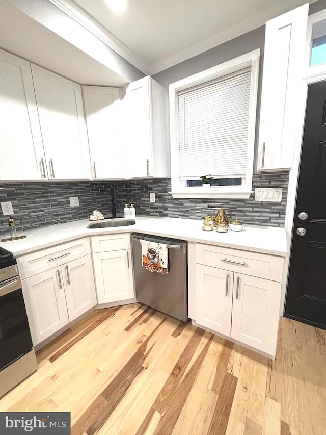 kitchen with sink, white cabinetry, stainless steel appliances, and tasteful backsplash