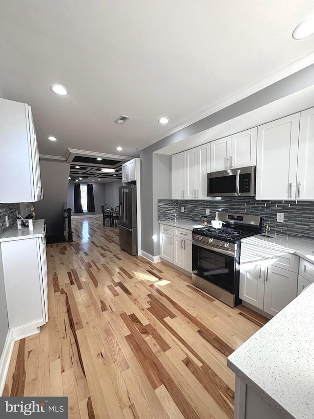 kitchen featuring appliances with stainless steel finishes, light wood-type flooring, and white cabinetry