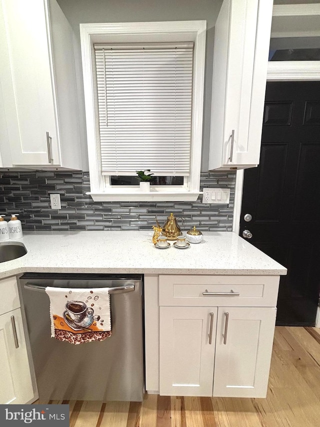 kitchen featuring dishwasher, decorative backsplash, white cabinets, and light stone countertops