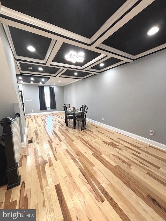 interior space with beamed ceiling, light hardwood / wood-style floors, coffered ceiling, and ornamental molding