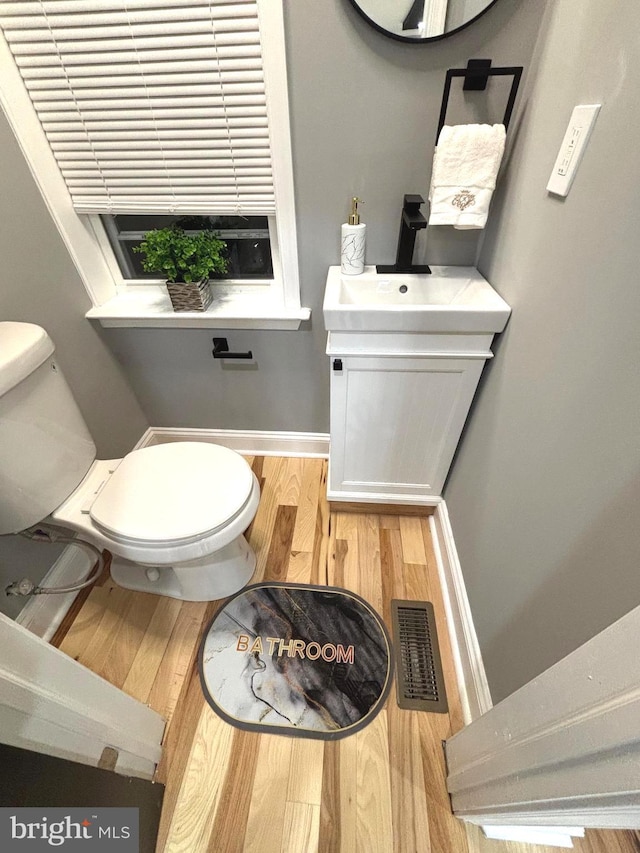 bathroom featuring hardwood / wood-style floors, vanity, and toilet