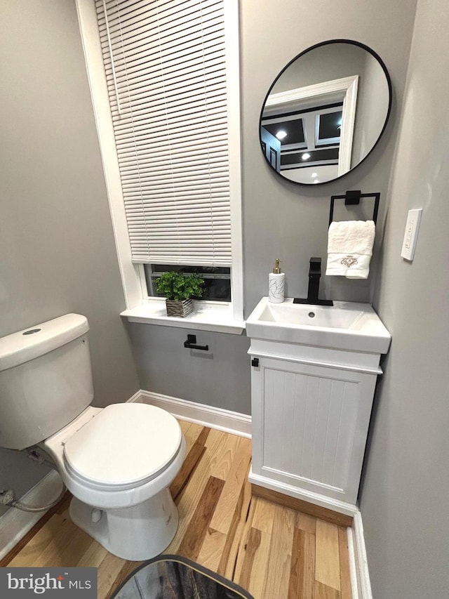 bathroom with hardwood / wood-style floors, vanity, and toilet