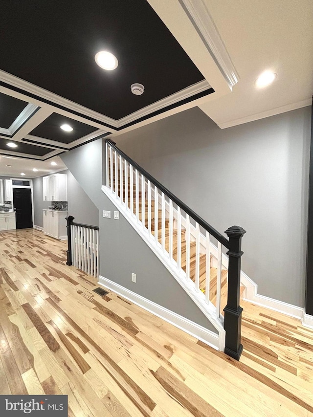 staircase featuring hardwood / wood-style flooring and crown molding